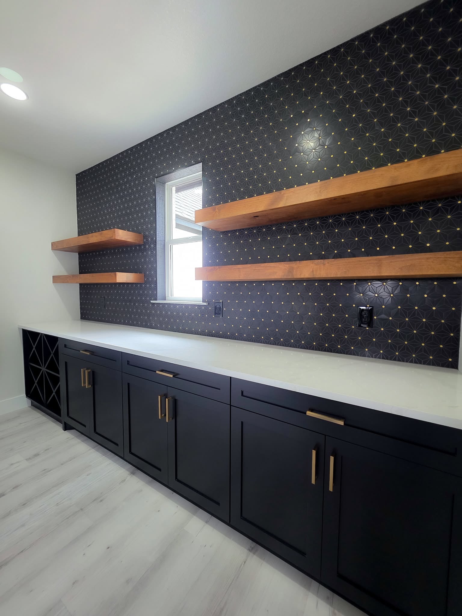 Gold and brass bar pulls on a dark wet bar unit's cabinet doors and drawers