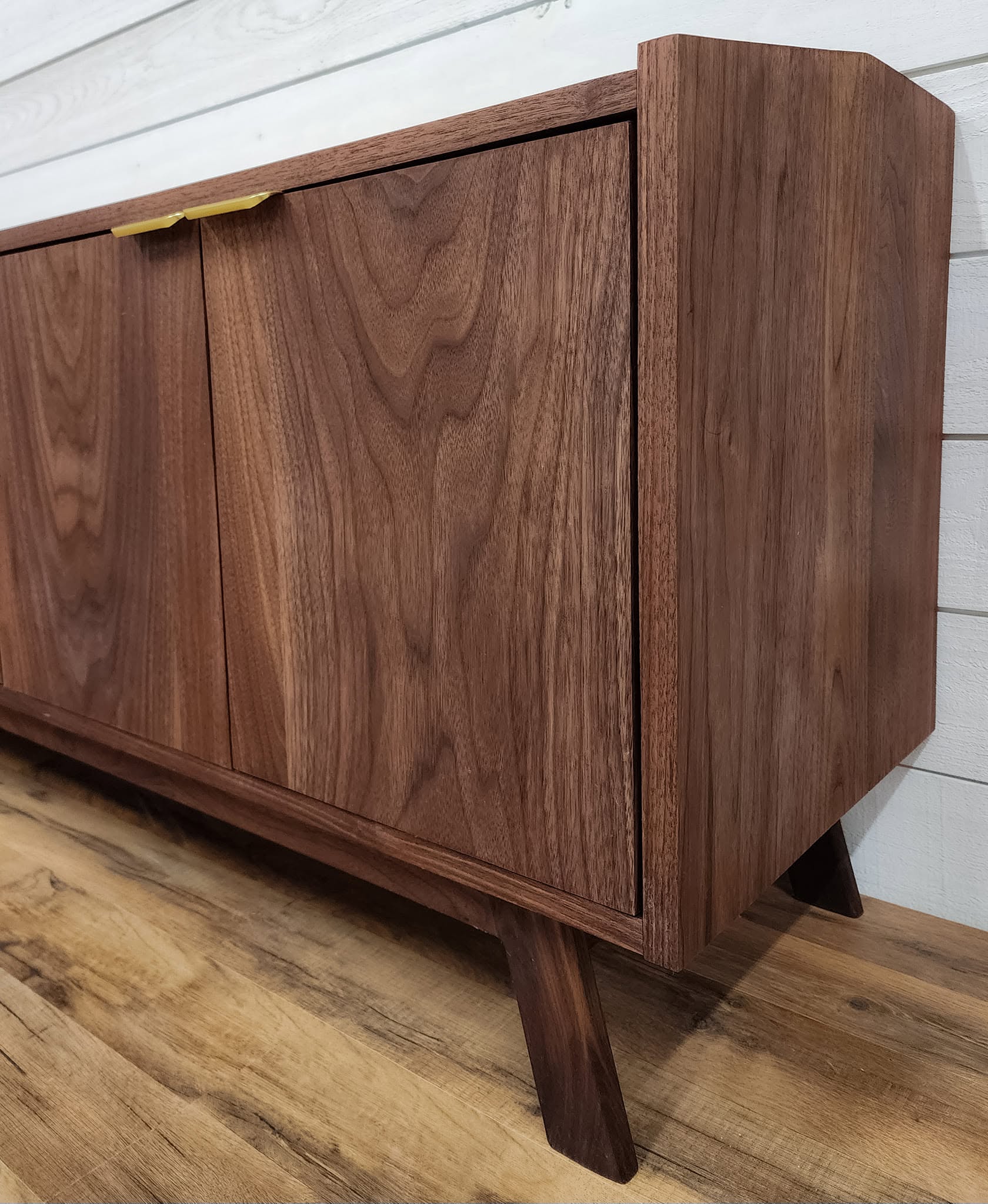 Gold angular bar pulls on a walnut credenza corner