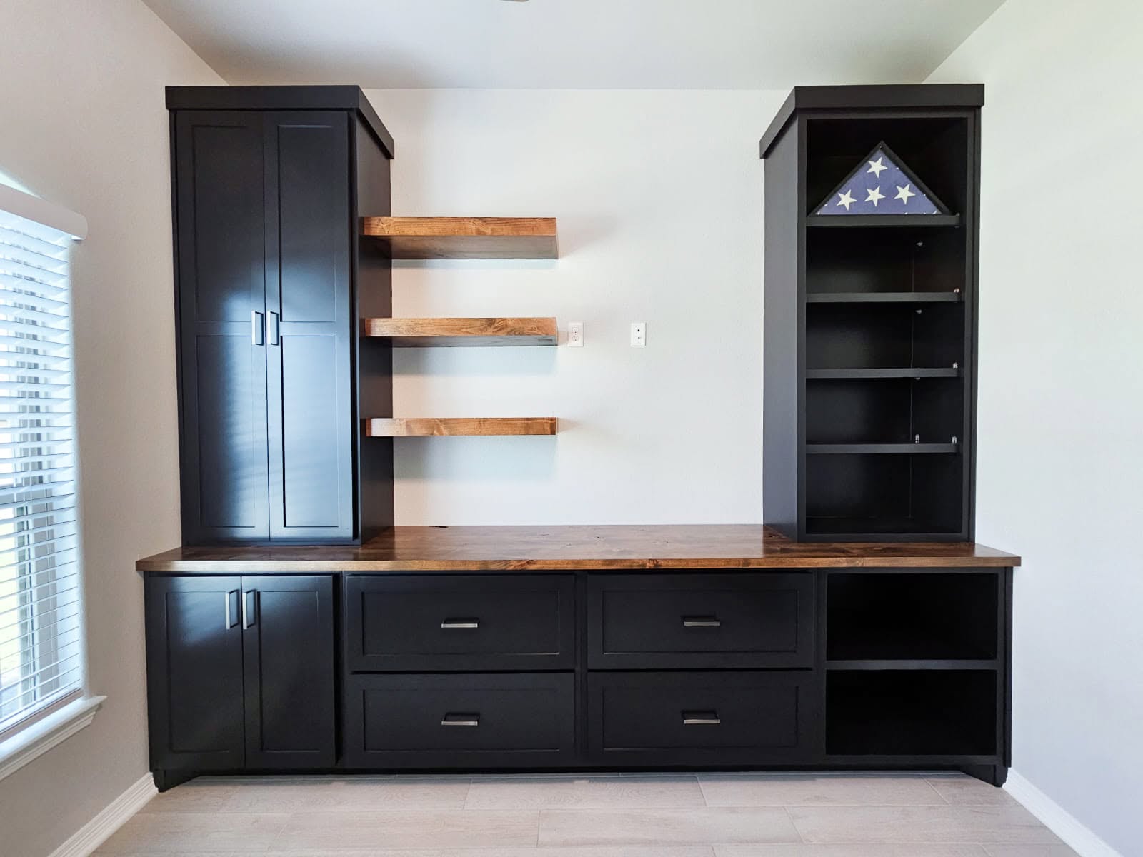 Brushed silver bar pulls on a built-in wall unit's drawers