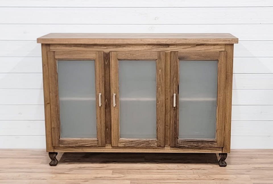 White and cream oval knobs on a wood sideboard's frosted-glass doors