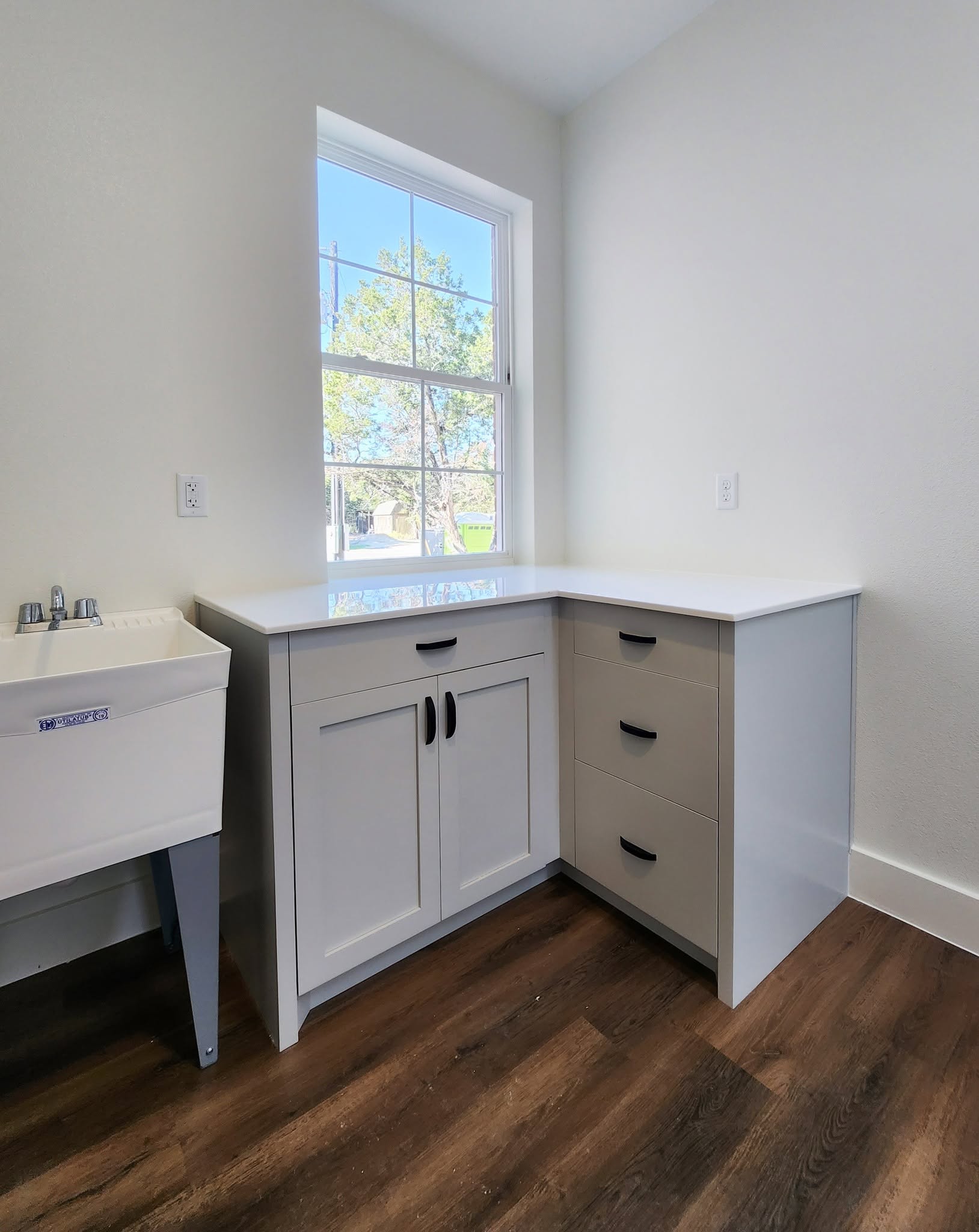 Matte black bar pulls on a white laundry room cabinet