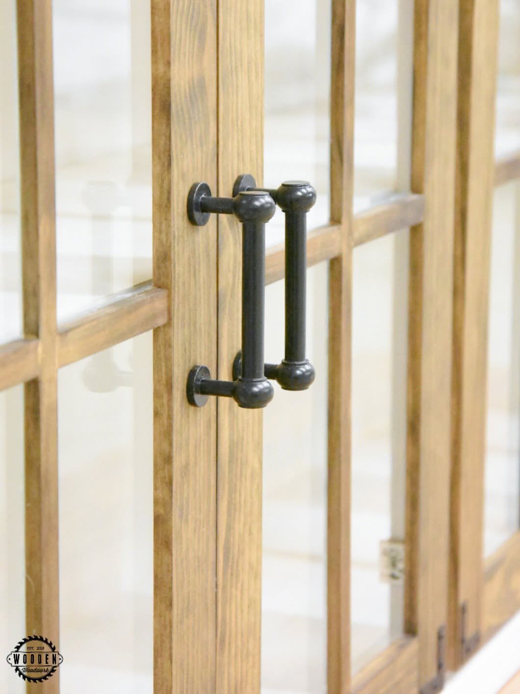 Black decorative corner bracket on a glass-front cabinet door