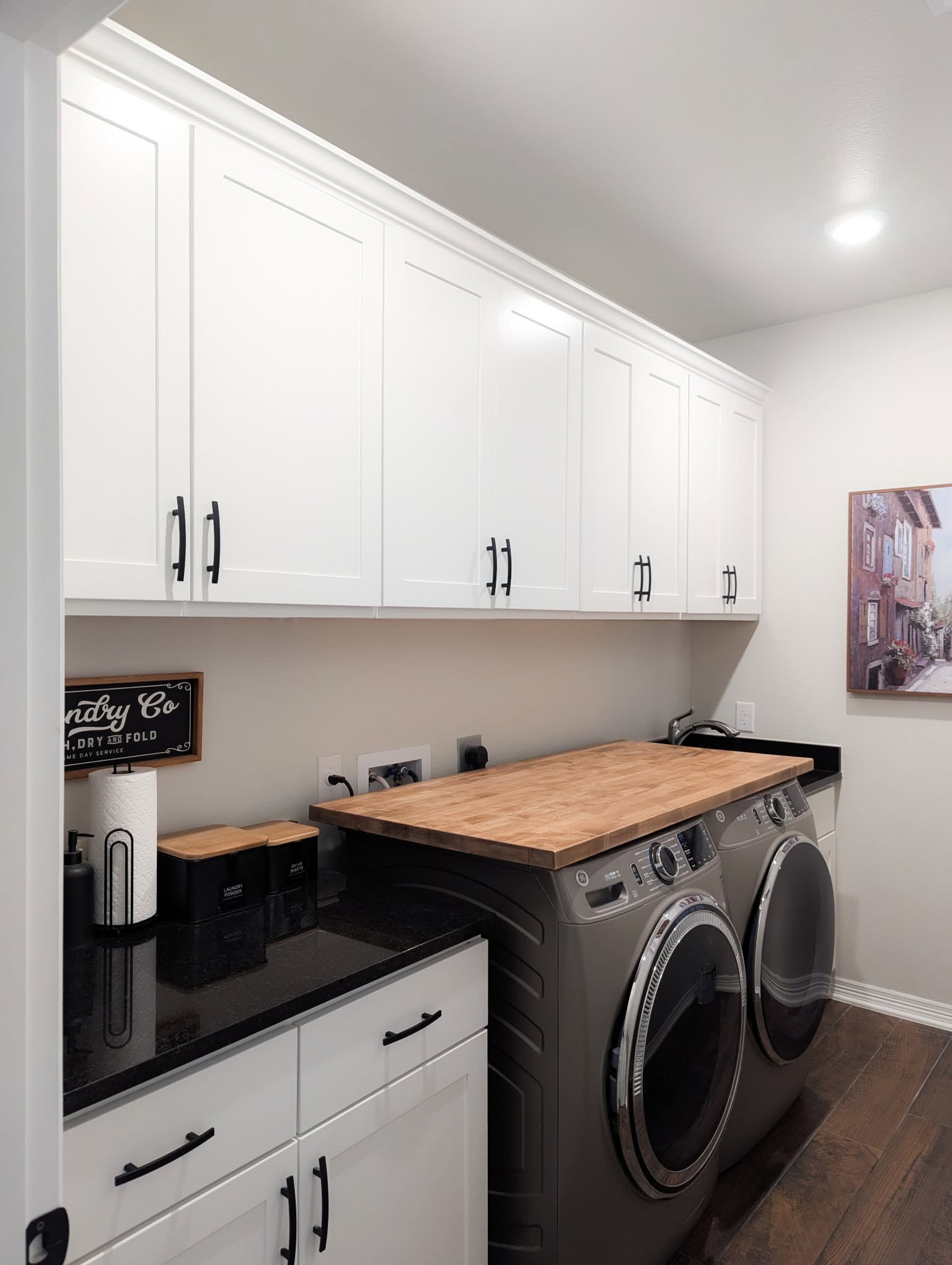 Black loop-style pulls on six matching laundry room cabinet doors