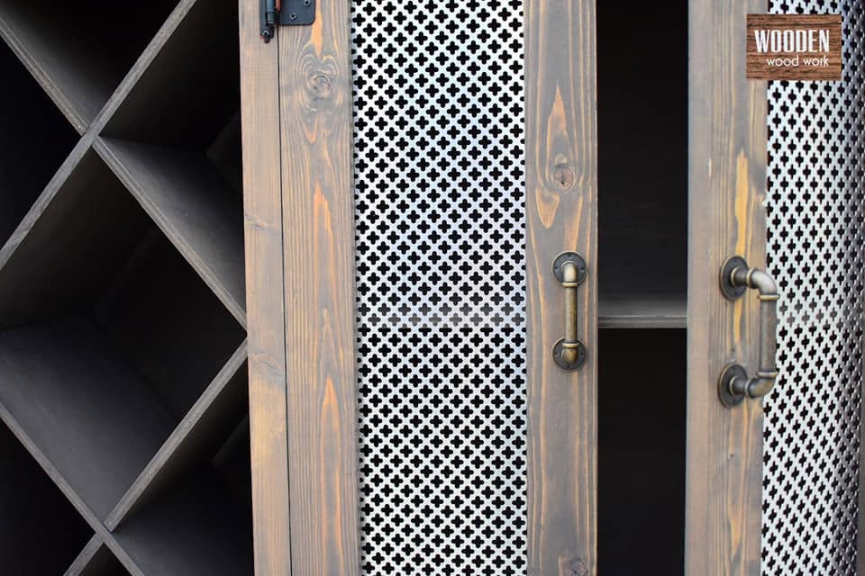 Black pipe-style door pulls on mesh-panel cabinet doors