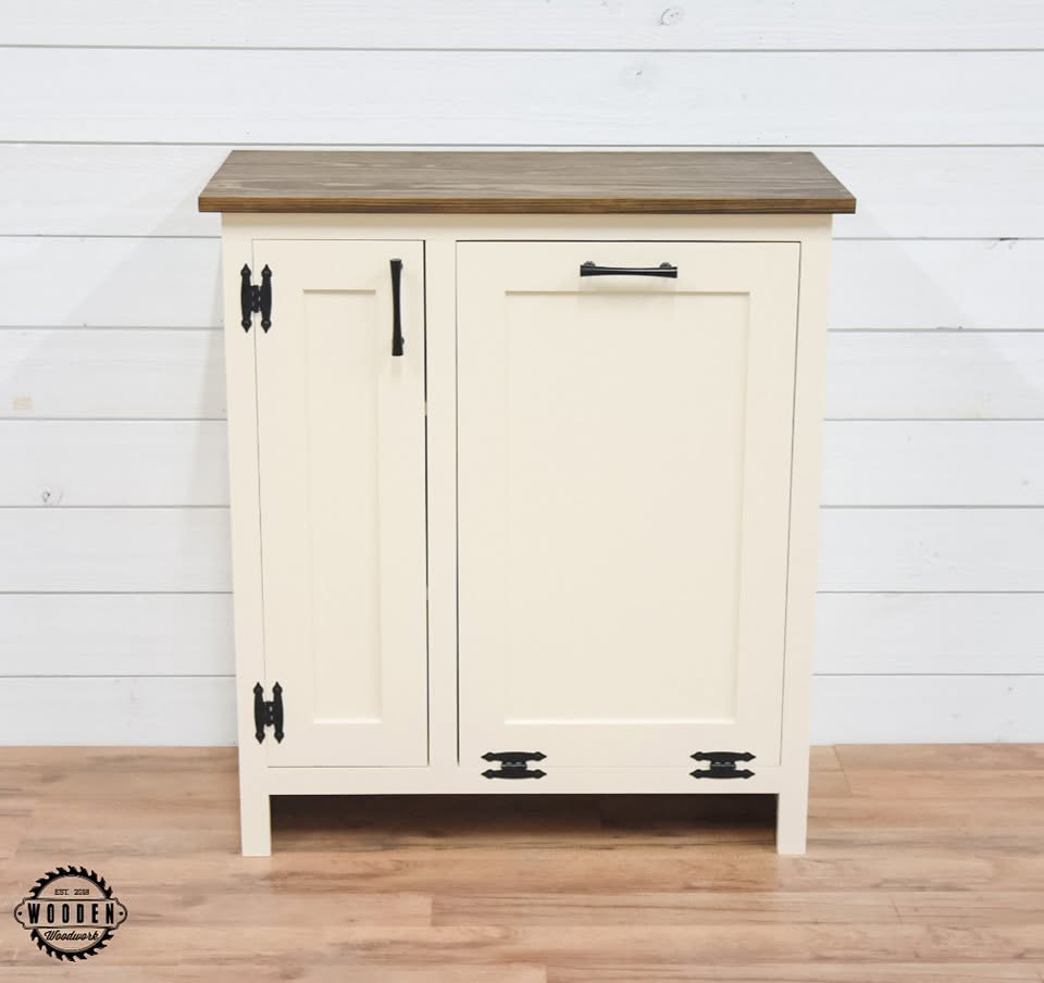 Black decorative strap hinges and bar pull on a tilt-out trash cabinet
