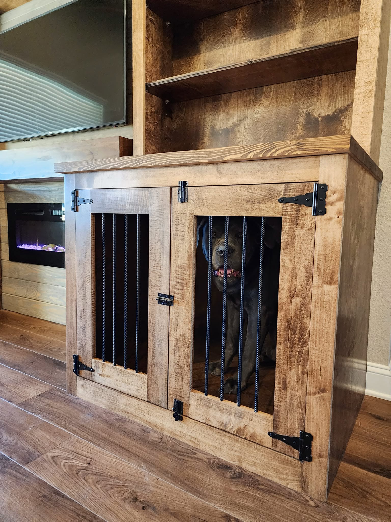 Black strap hinges and slide-bolt latches on a wood kennel door