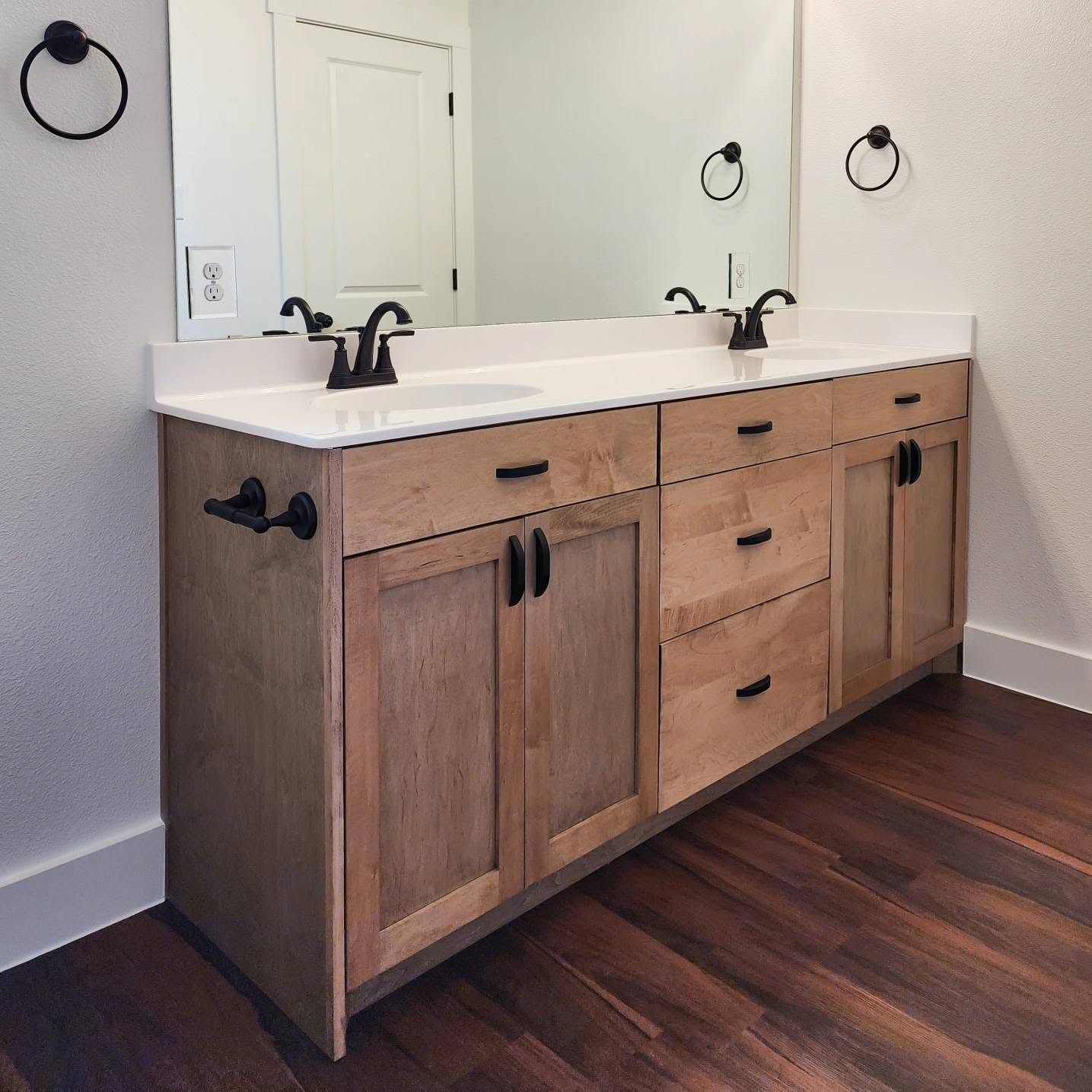 Oil-rubbed bronze ring towel holder, hook, and black pulls on a vanity
